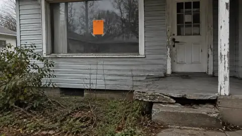 Code violation notice on the window of a neglected house with a broken step