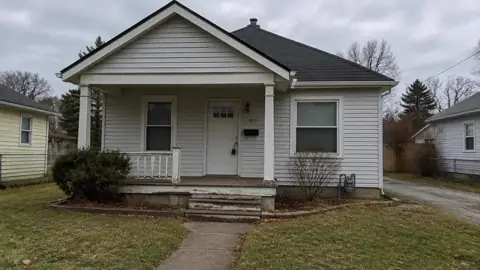 Modest single-family rental house with a lockbox on the front door