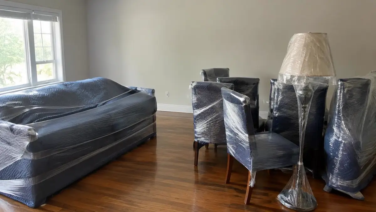 Living room furniture wrapped in moving blankets